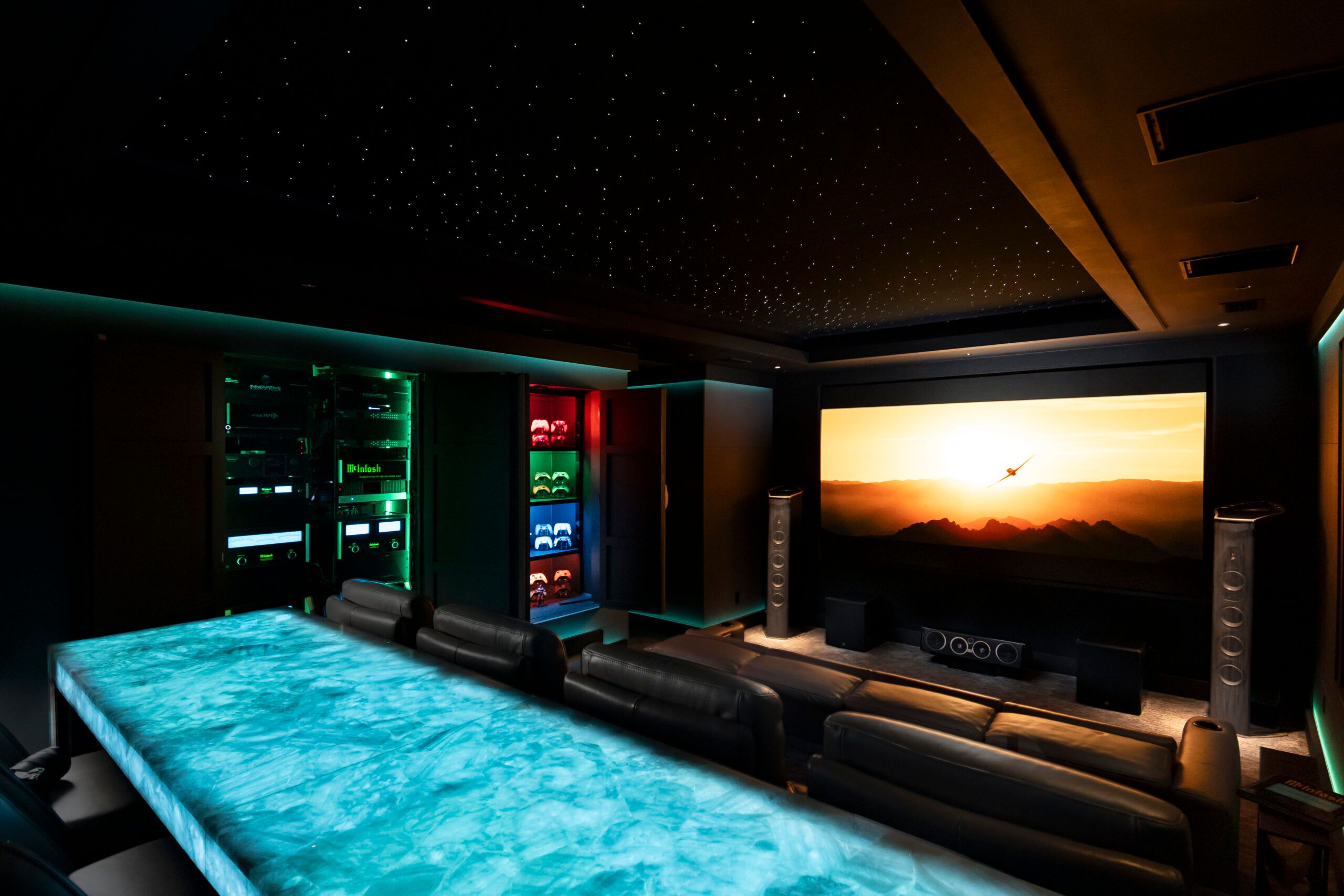 Dedicated home theater with a lit stone bar and a wall-size screen on 30A